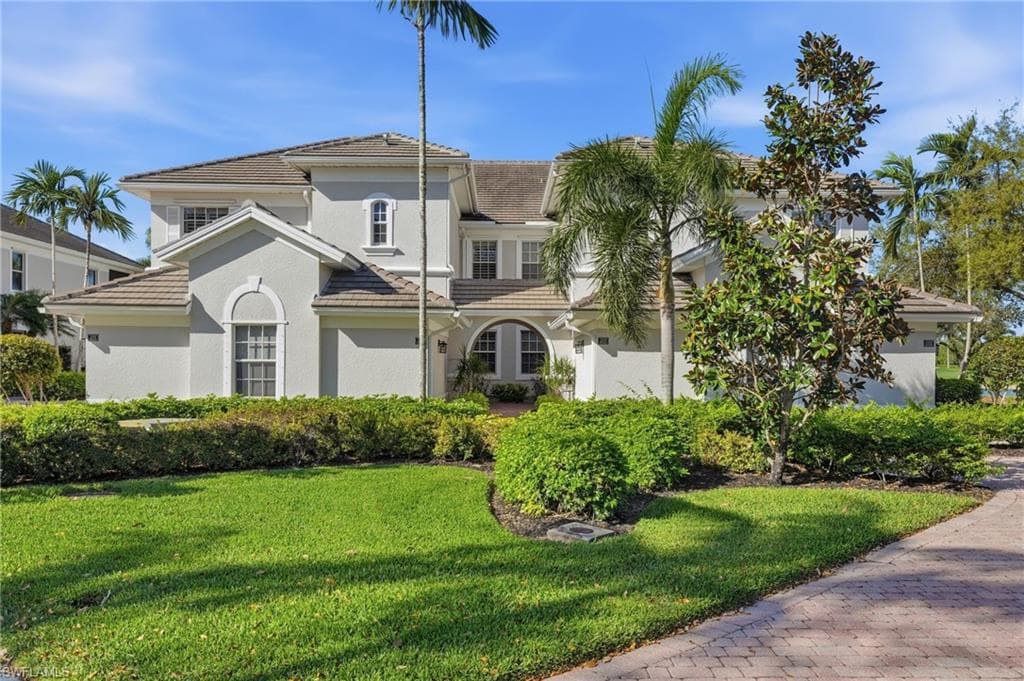 Mediterranean / spanish house with a tile roof, a front yard, and stucco siding