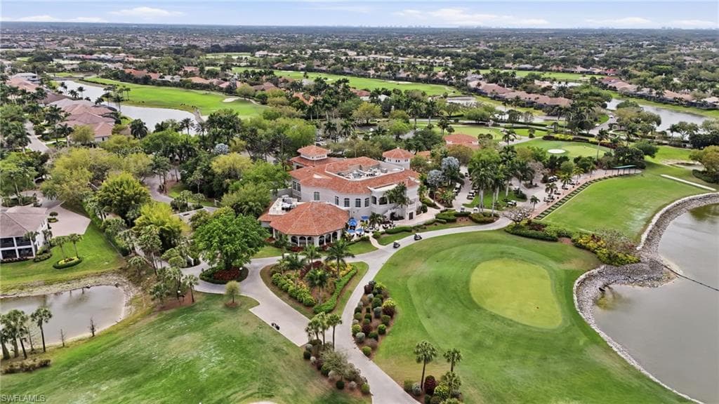 Aerial view of residential area featuring a nearby body of water and a local golf course