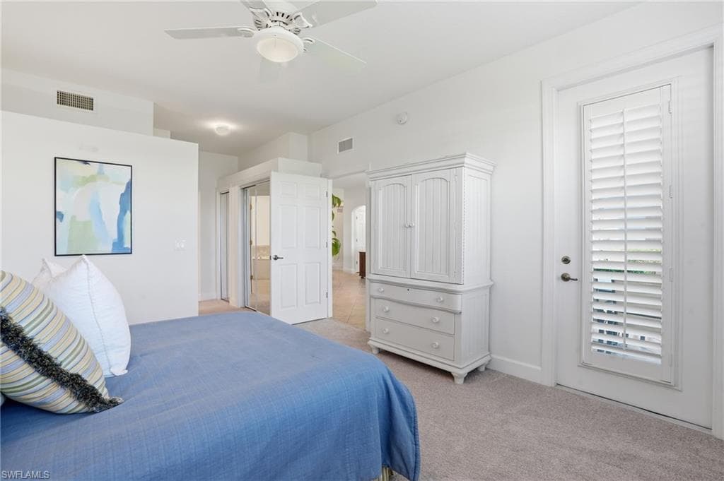 Bedroom with a ceiling fan and light carpet