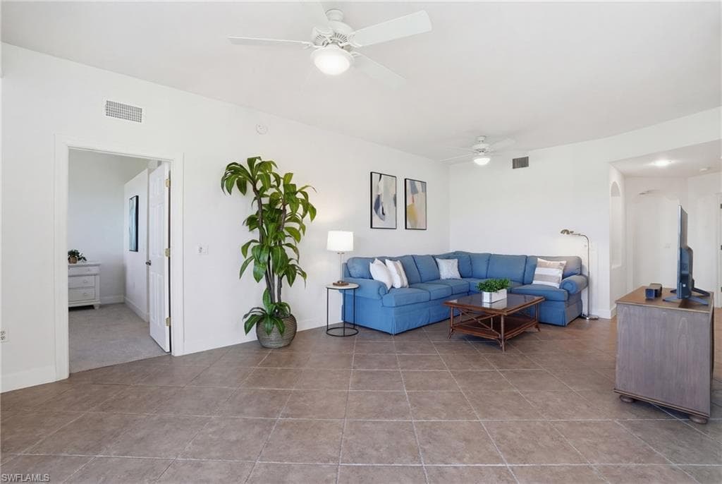 Living area with ceiling fan and light tile patterned floors