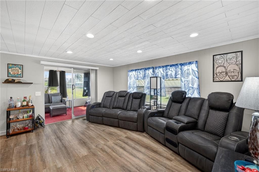 Living room featuring light wood-type flooring, recessed lighting, ornamental molding, and wood ceiling