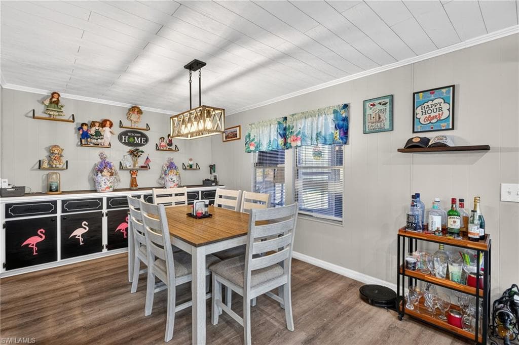 Dining area with wood finished floors and crown molding