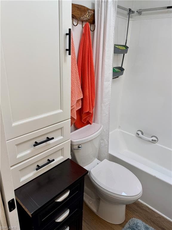 Full bath featuring wood finished floors and shower / tub combo