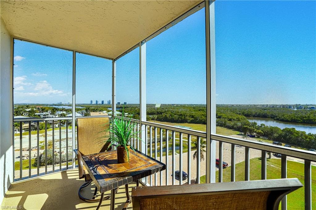 Sunroom featuring expansive windows and a water view