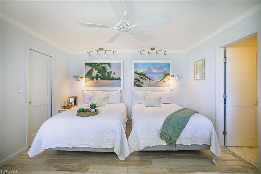 Bedroom with light wood finished floors, ceiling fan, and ornamental molding