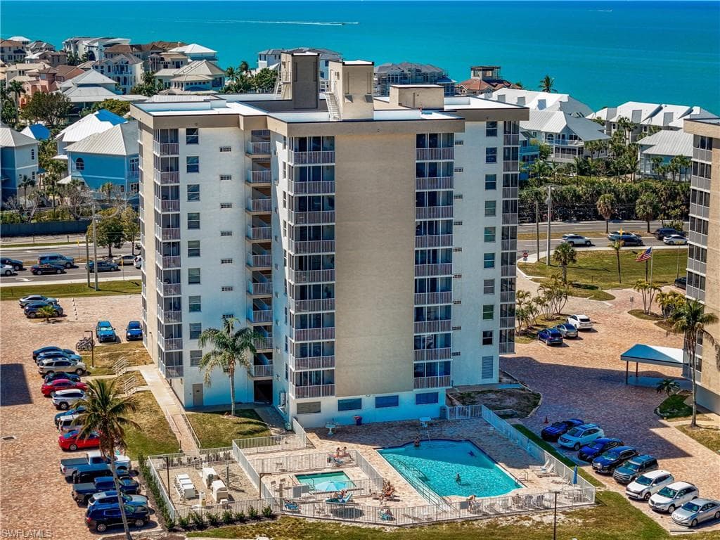 View of apartment building / complex with a water view, a community pool, and a residential view
