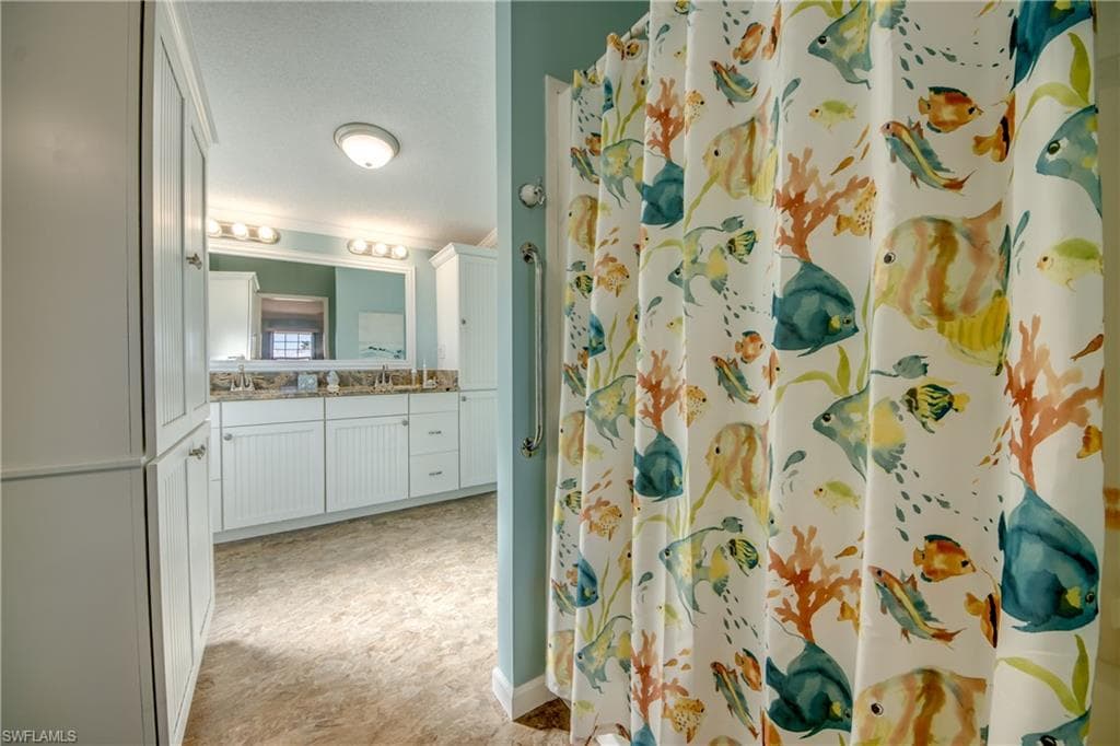 Full bathroom with vanity, curtained shower, and ornamental molding