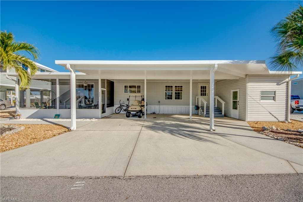 Rear view of property featuring a carport, driveway, and entry steps