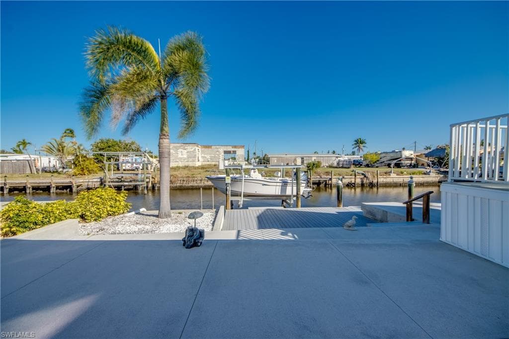 View of patio / terrace with a boat dock, a water view, and boat lift