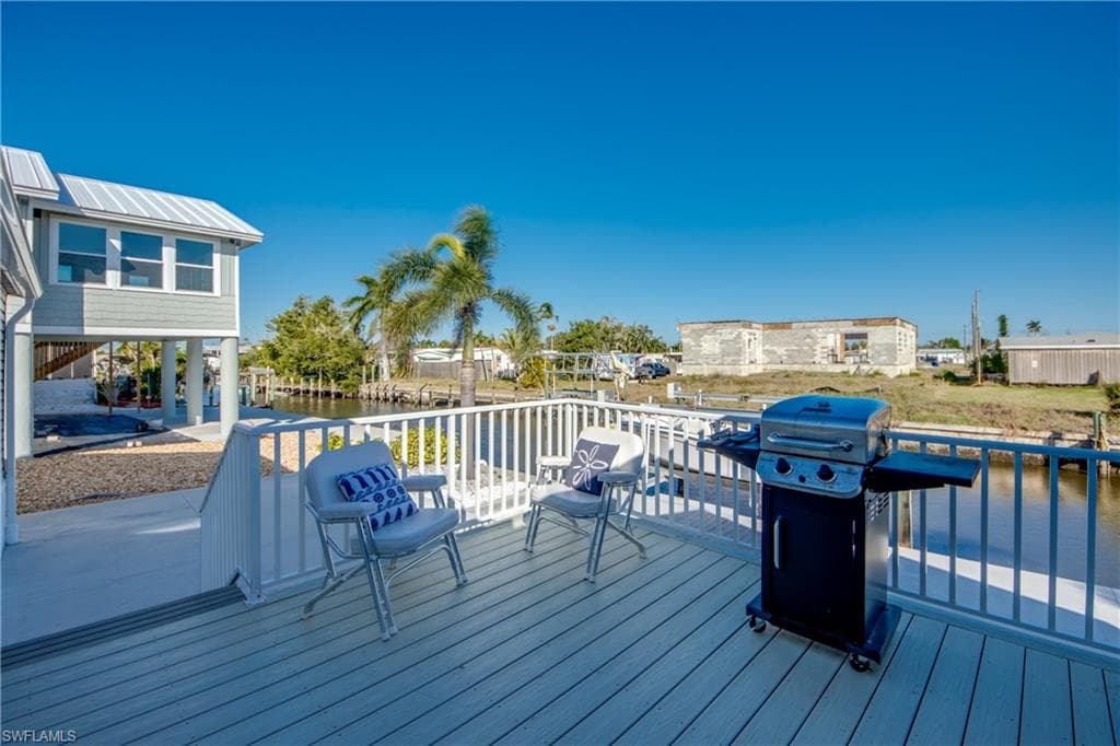Deck with a grill, a residential view, and a water view
