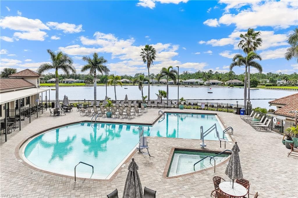 View of community pool with a water view and a patio