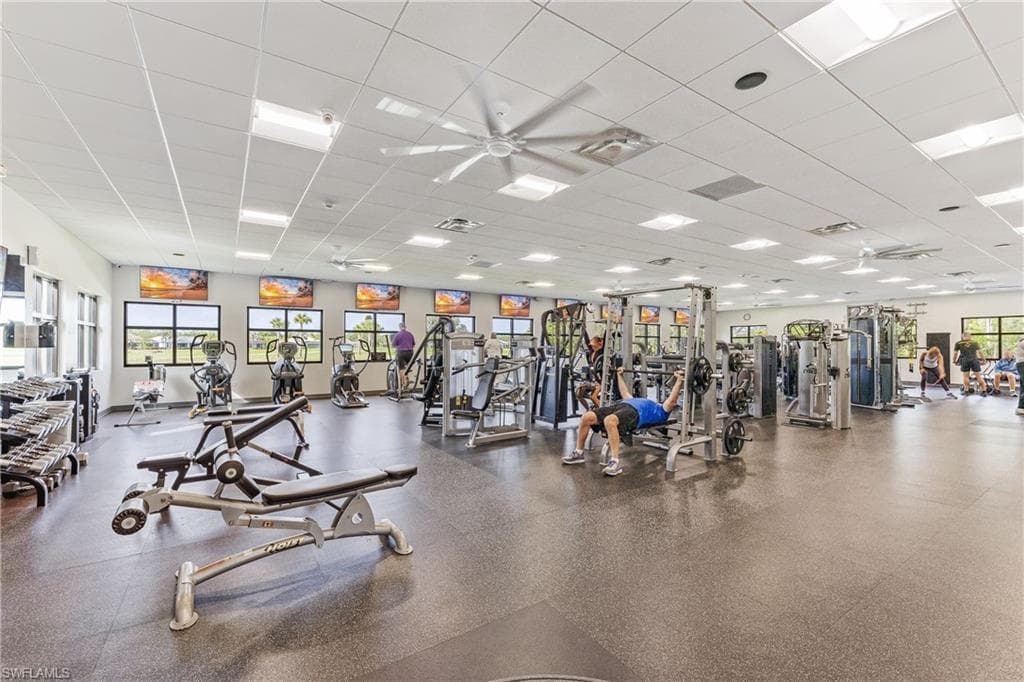 Exercise room with ceiling fan and a paneled ceiling