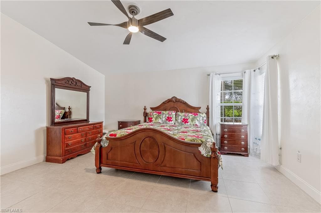Bedroom with ceiling fan and light tile patterned flooring