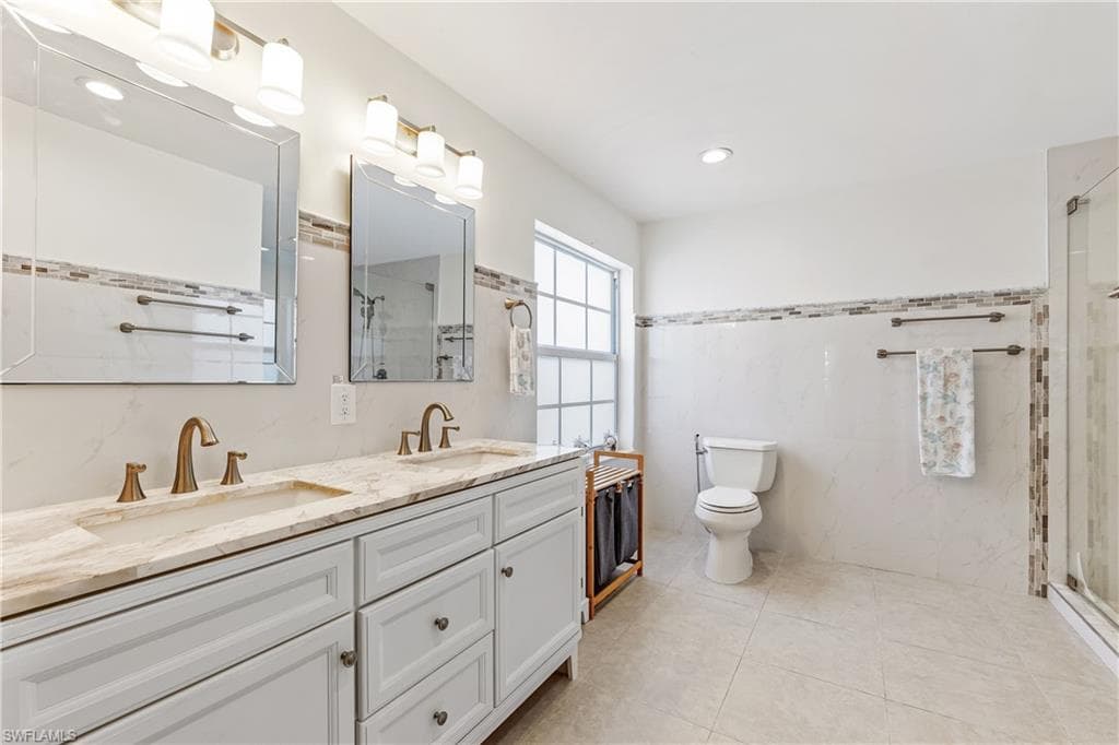 Updated Master Bathroom featuring a shower with shower door, toilet, and vanity, and tiled floors