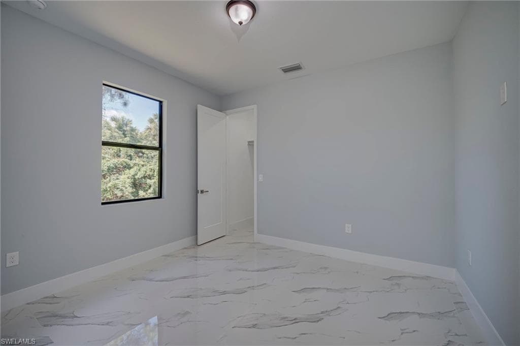 Spare room featuring light marble finish flooring