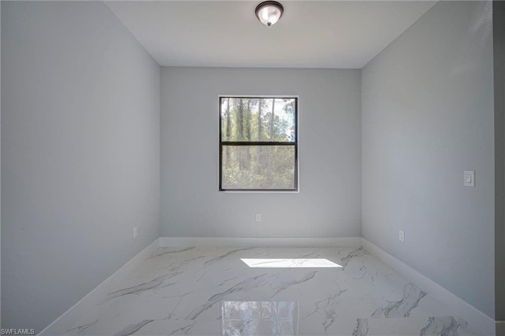 Spare room with light marble finish flooring and baseboards