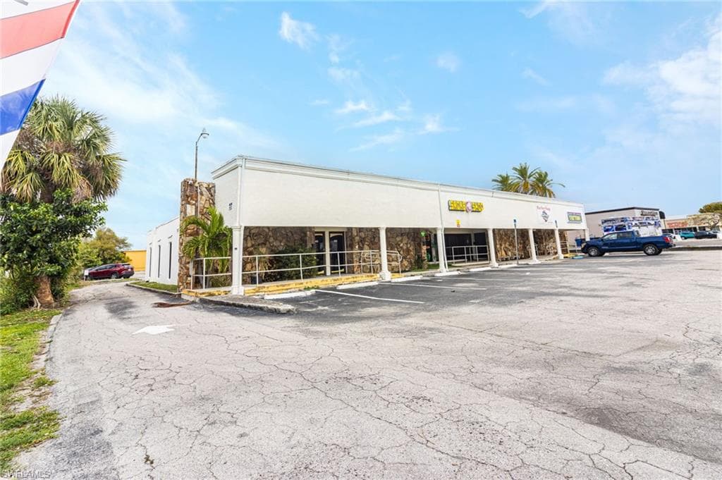 View of commercial property with uncovered parking