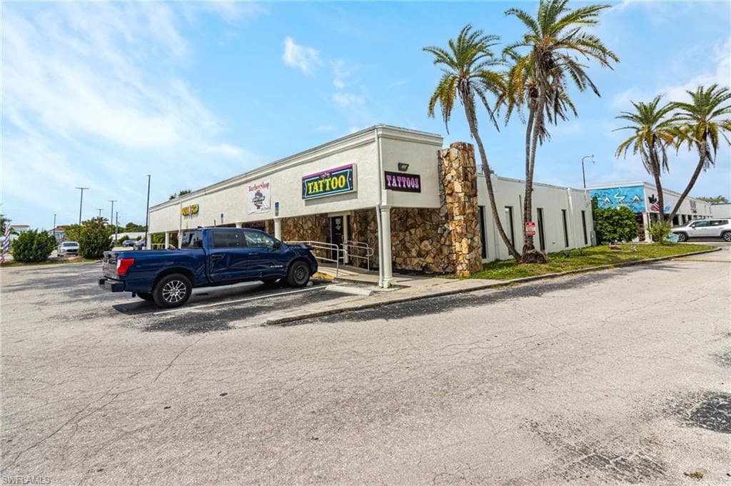 View of commercial property featuring uncovered parking
