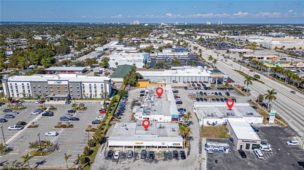 Aerial view of property and surrounding area featuring a commercial area