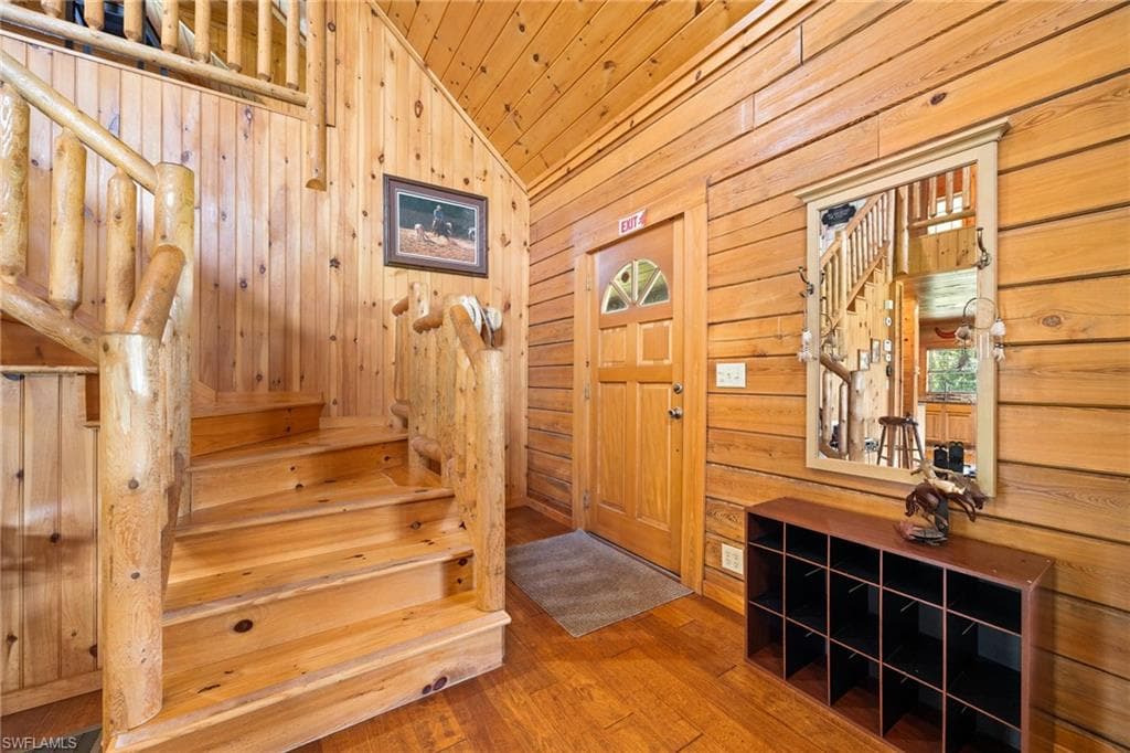 Entryway featuring hardwood / wood-style flooring, wood walls, and a vaulted wooden ceiling