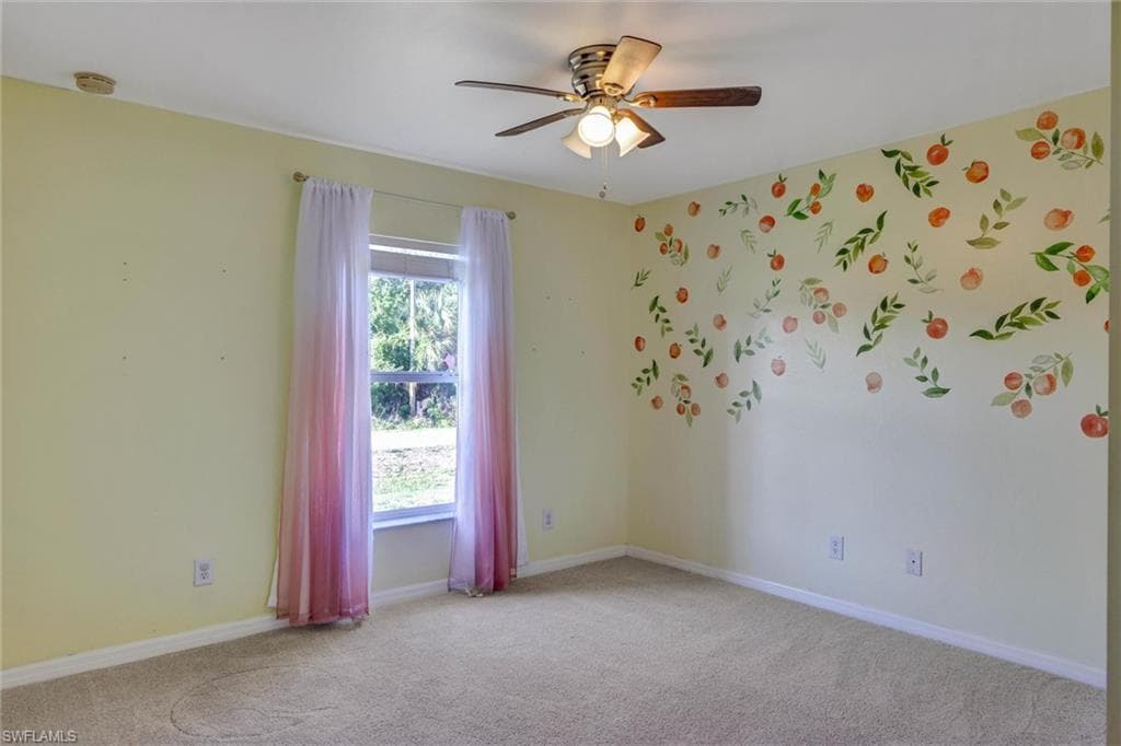Unfurnished room featuring light carpet and ceiling fan