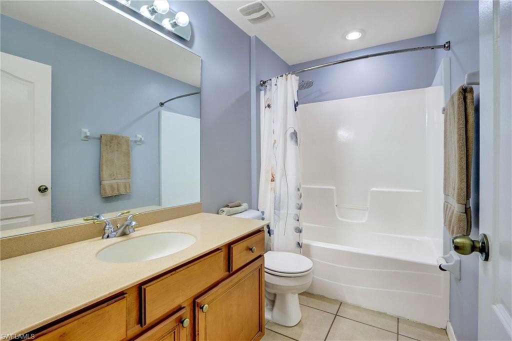 Full bathroom featuring light tile patterned floors, vanity, and shower / bath combo