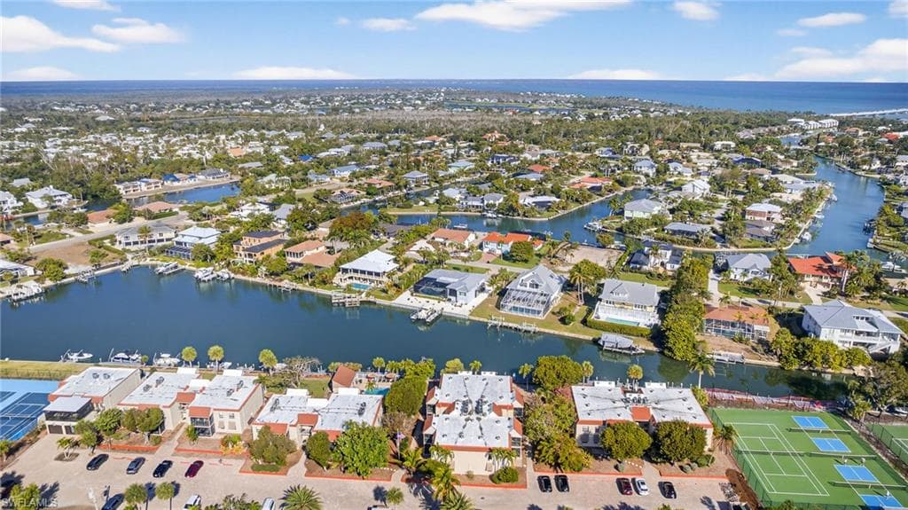 Aerial view of property's location featuring a nearby body of water and nearby suburban area