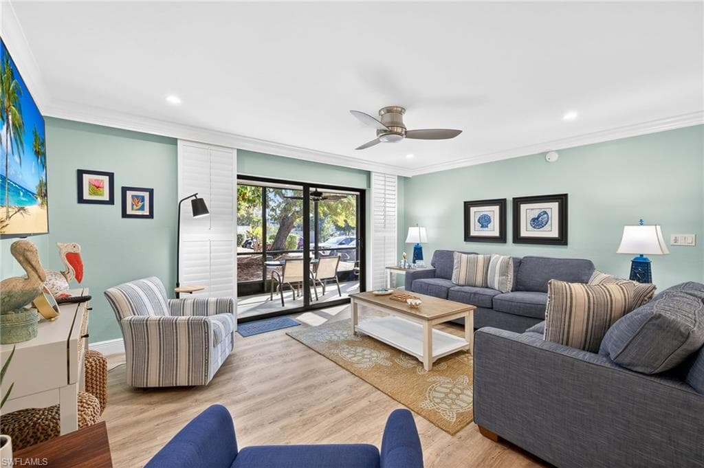 Living room with crown molding, wood finished floors, ceiling fan, and recessed lighting