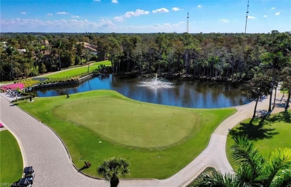 View of property's community featuring a water view, view of golf course, and view of scattered trees