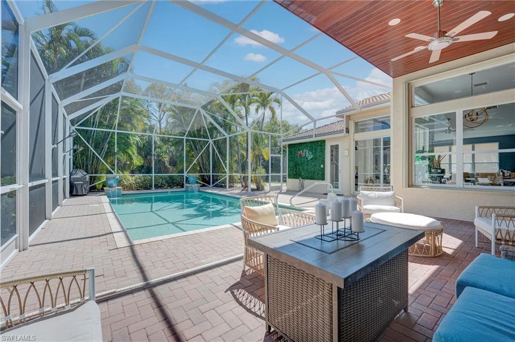 Swimming pool featuring a patio area, a sunroom, and a lanai