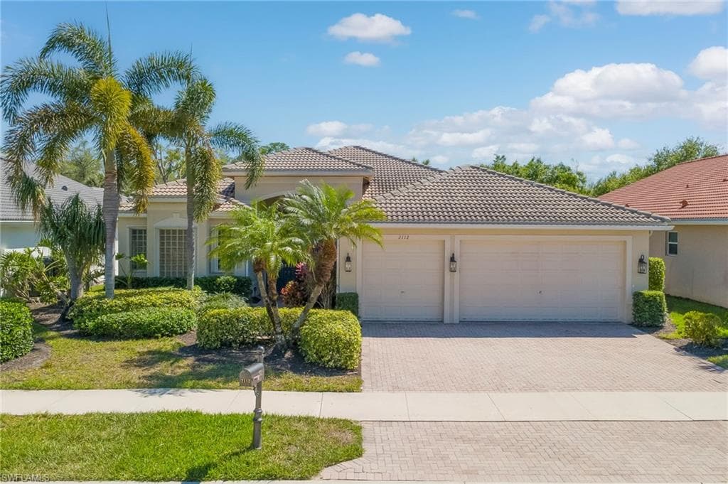 View of front of property with an attached garage, decorative driveway, stucco siding, and a tile roof