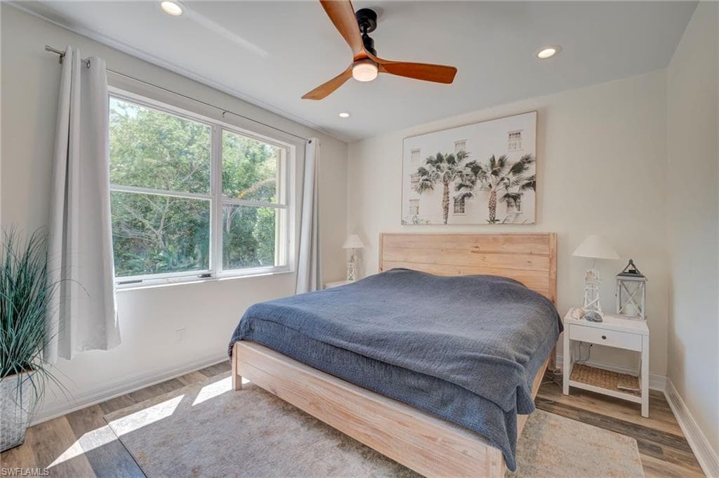 Bedroom with wood finished floors, a ceiling fan, and recessed lighting