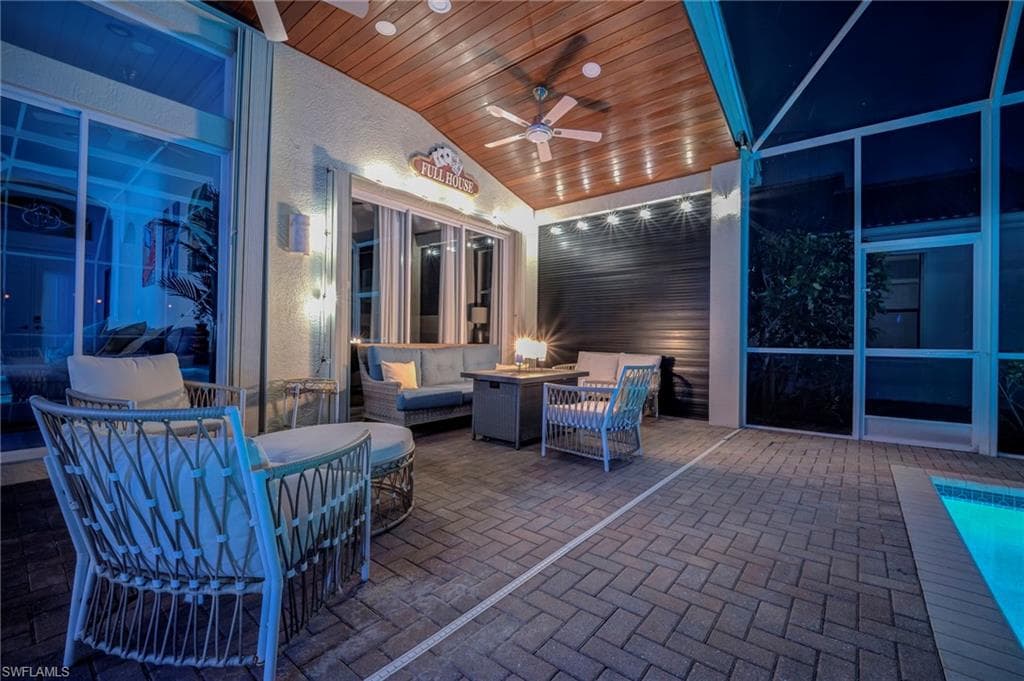 View of patio with an outdoor living space with a fire pit and a ceiling fan