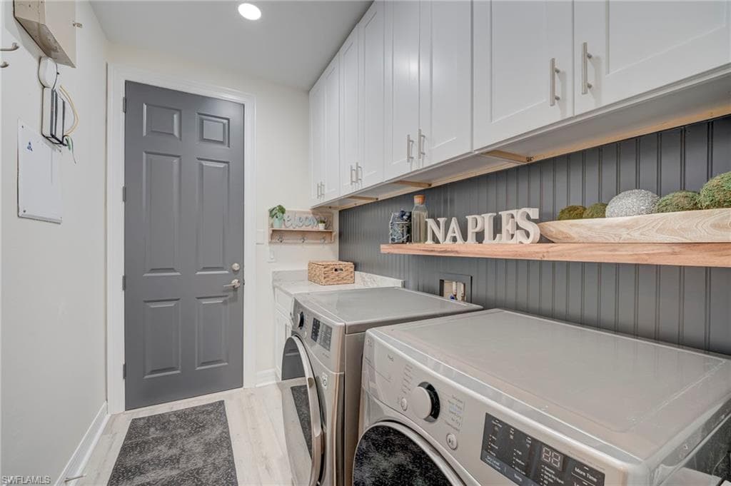 Laundry area with cabinet space, independent washer and dryer, light wood-style flooring, and recessed lighting