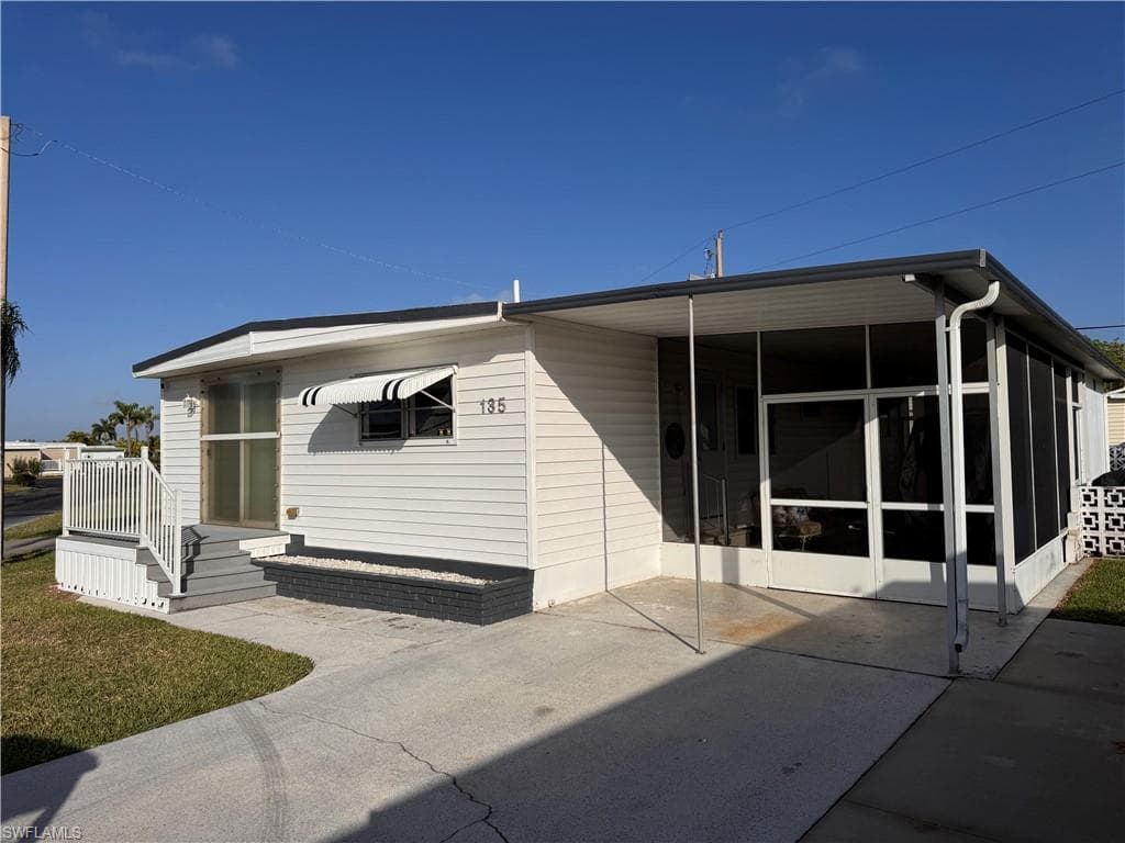 Angle photo of home, showing great parking and double-door entry to screen room.
