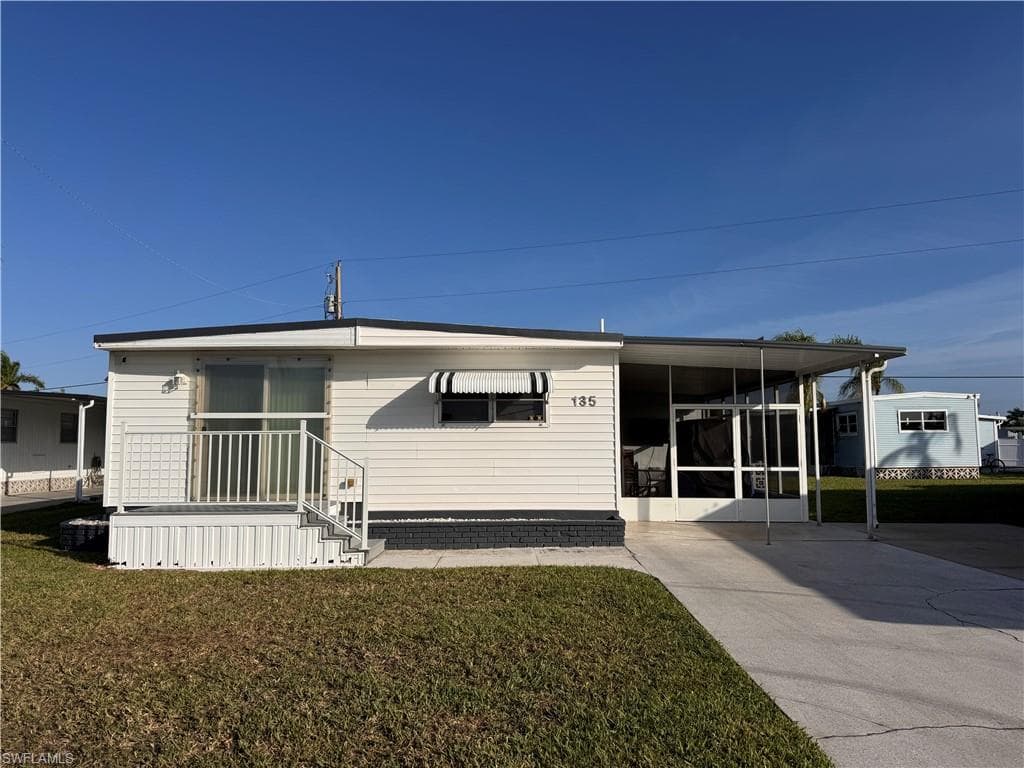 Front of home, slider featured with hurricane protection cover. Ample Parking