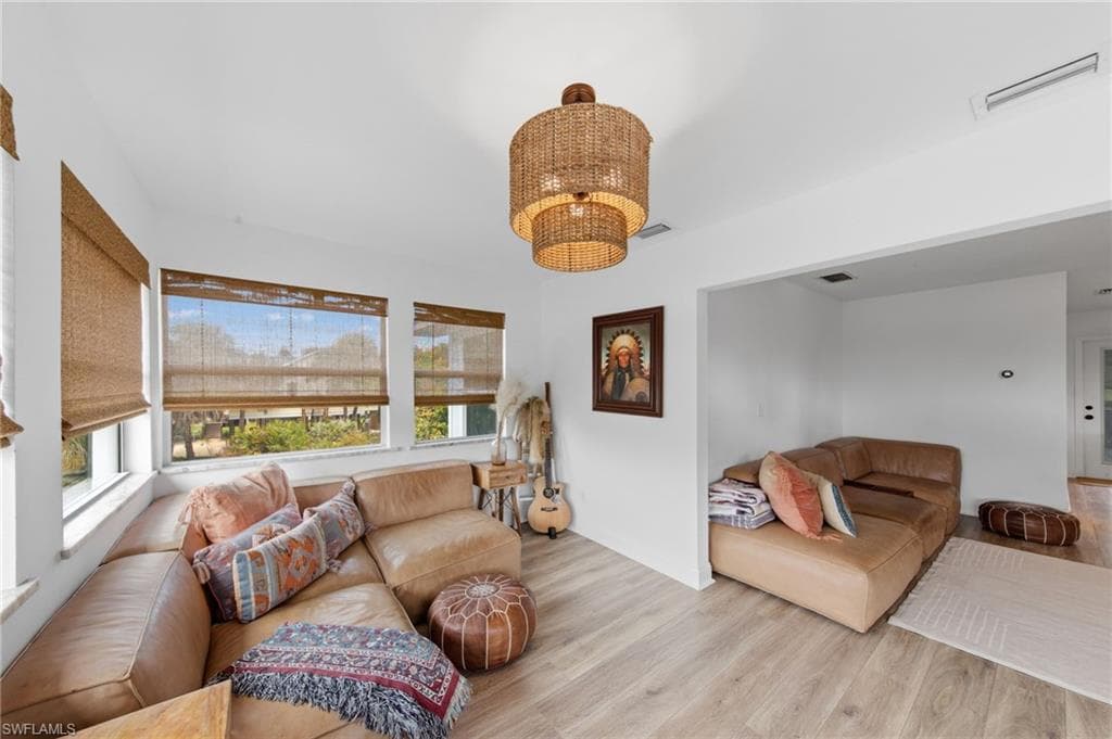 Living area featuring light wood-type flooring and hanging lights