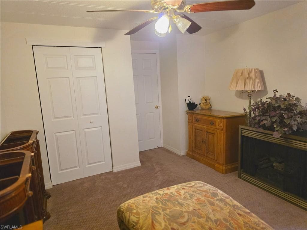 Bedroom with light carpet, a closet, and ceiling fan
