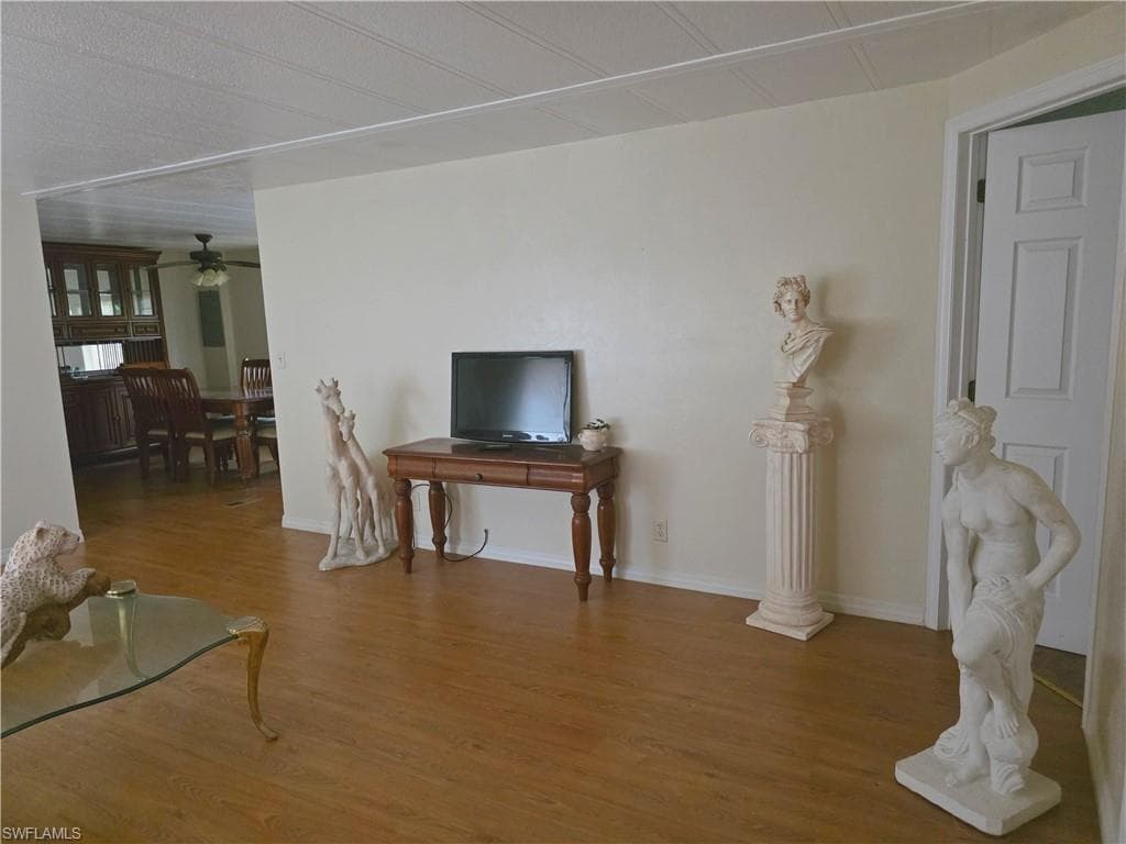 Living room featuring ceiling fan and wood finished floors
