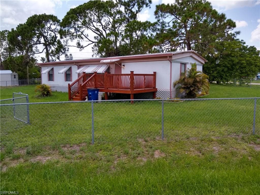 View of front facade with a deck and a fenced backyard
