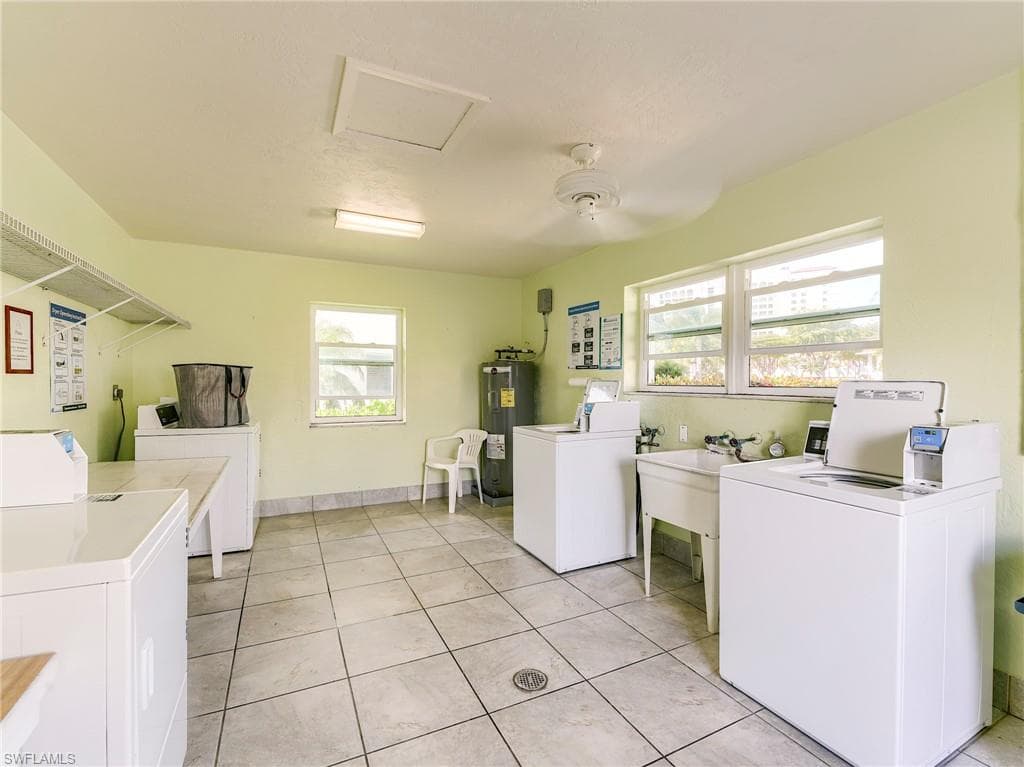 Communal laundry room featuring separate washer and dryer and water heater