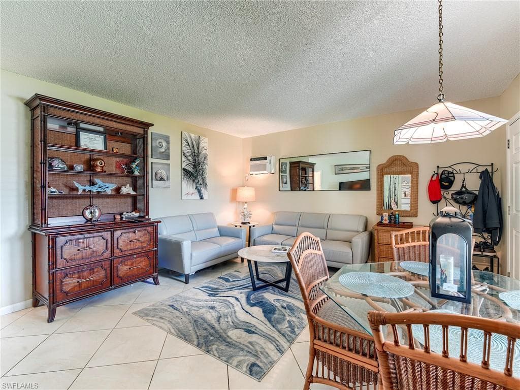 Living room featuring a textured ceiling and light tile patterned floors