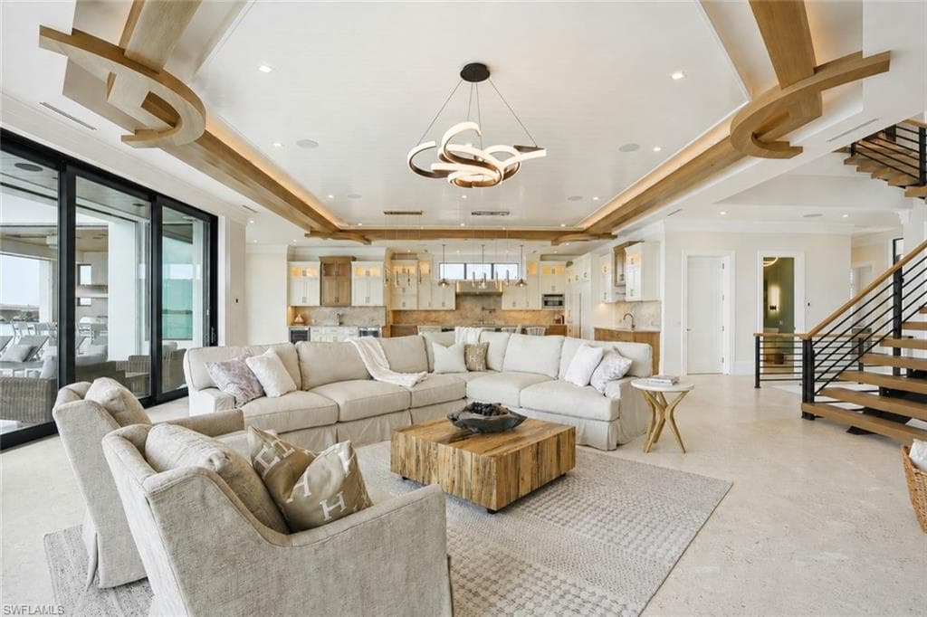 Spacious open-concept living area featuring a coffered ceiling with integrated lighting and decorative wood accents - Virtually Edited Image