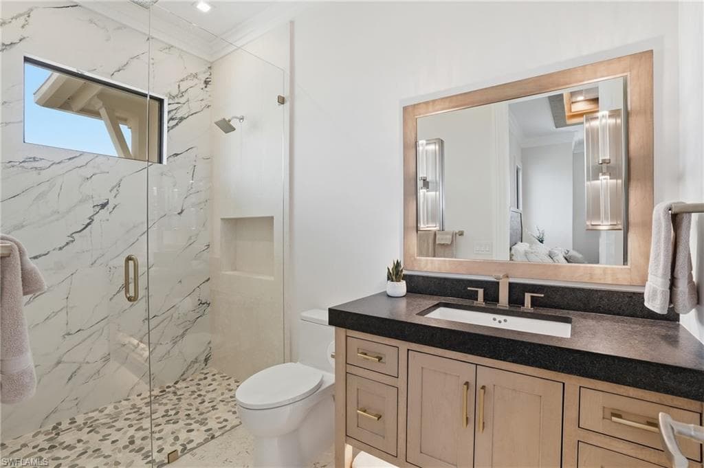 Full bathroom with vanity, a marble finish shower, crown molding, and ensuite bath - Virtually Edited Image