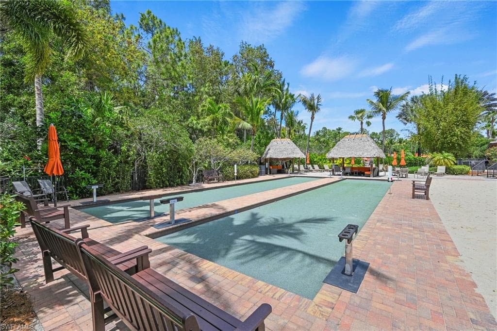 View of pool with patio surround, a game area, and a gazebo