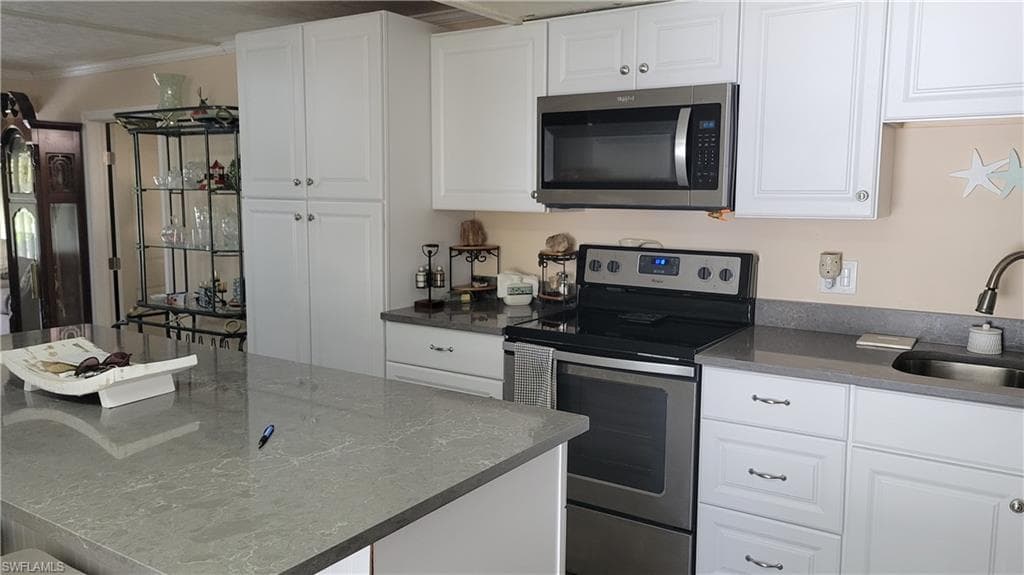 Kitchen with electric range and microwave. Large pantry to the left of range.