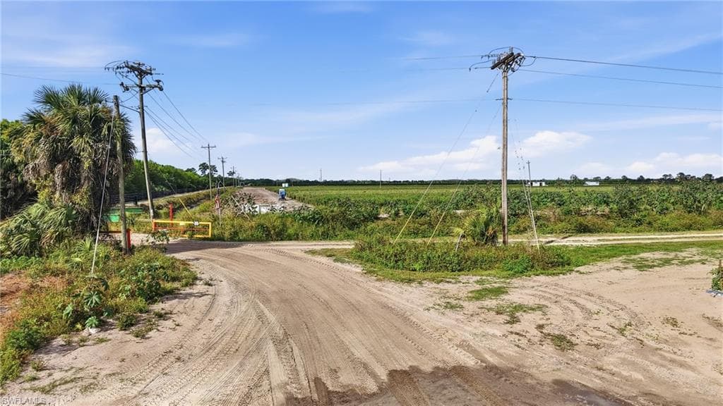 View of dirt / gravel road featuring a view of rural / pastoral area