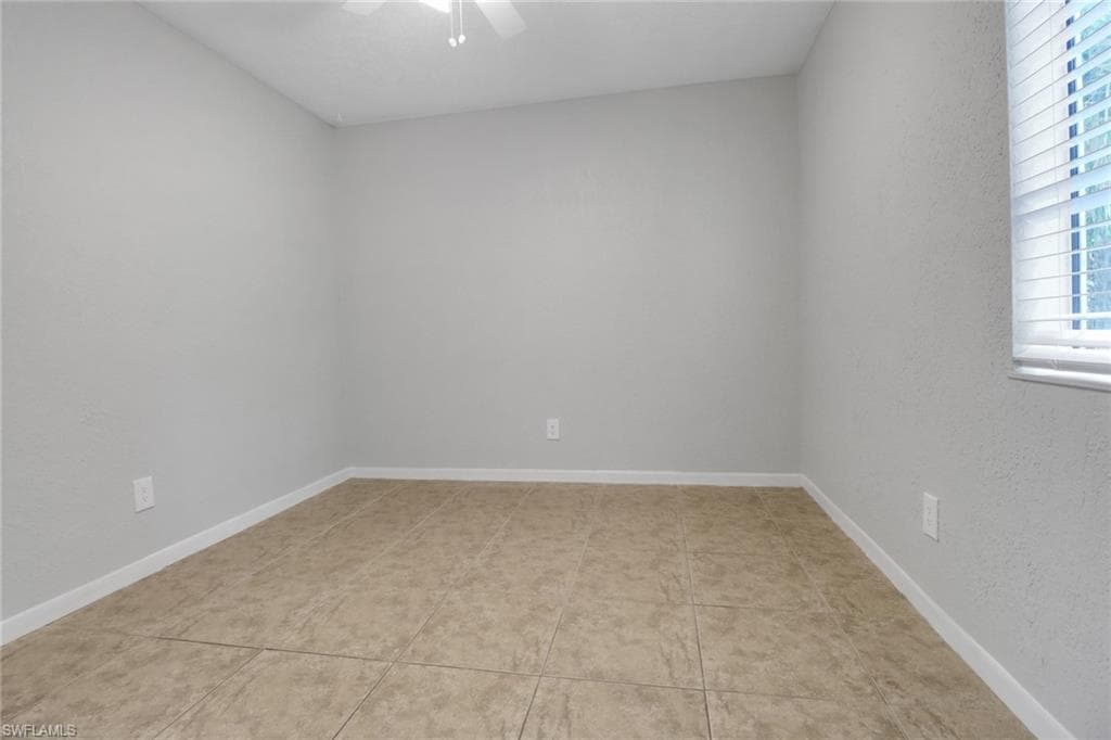 Unfurnished room with baseboards and a ceiling fan