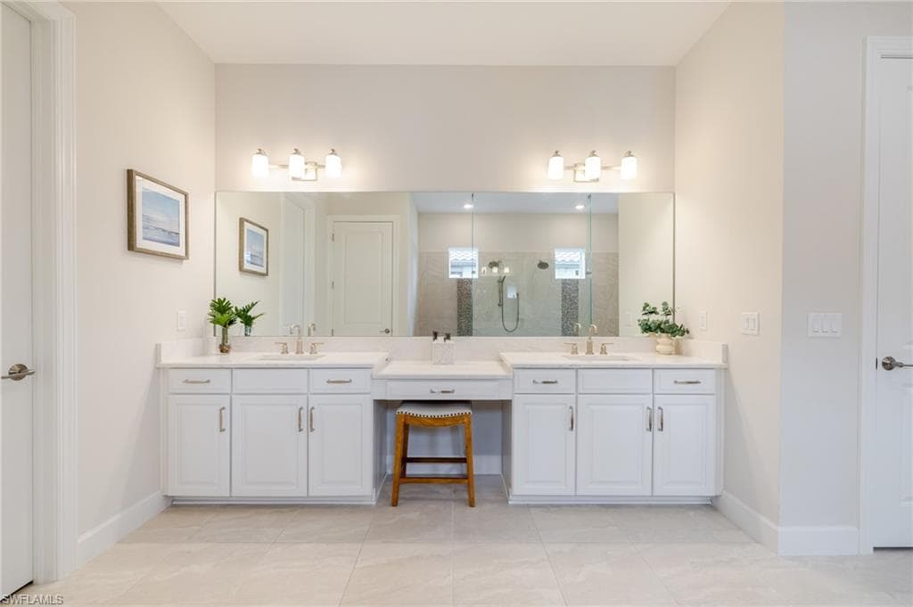 Bathroom with a shower stall, two vanities, and light tile patterned floors