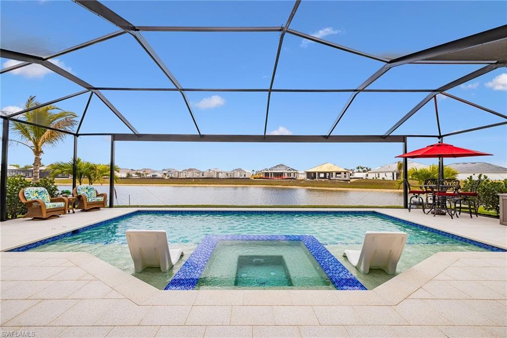 Combined pool / hot tub featuring a residential view, a sunroom, a patio, a water view, and a lanai
